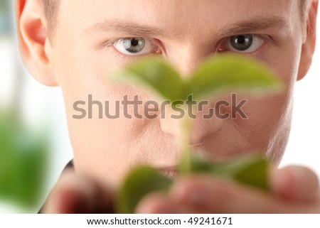 Businessman in dark suit holding small plant in his hands - growth concept