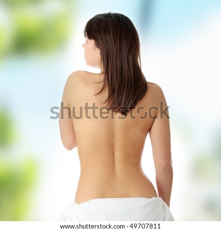Young beautiful woman topless, in towel, view from back