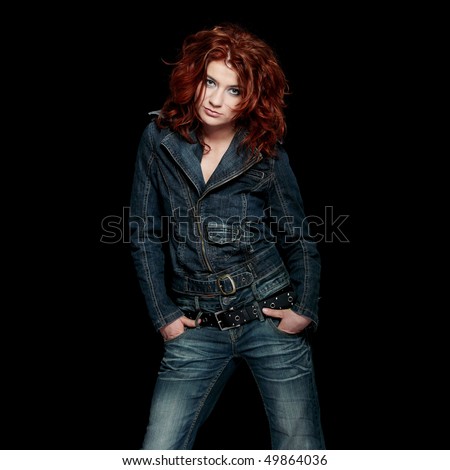 Redhead woman in jeans close up portrait, over black background