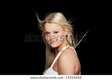 Young beautiful woman in  white dress and wind in her hairs (hair blowing), isolated on black background.