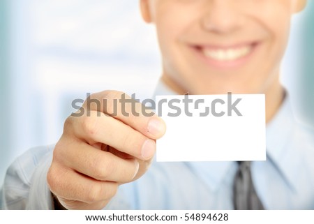 Young happy smiling successful business man with blank business card or sign