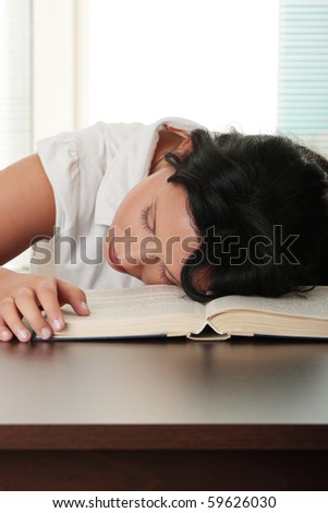Sleeping while learning - tired teen woman sleeping on desk