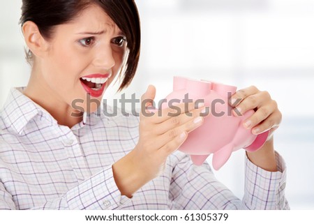 Young woman trying to get money from her piggy bank