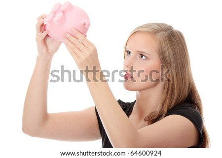 Young woman trying to get money from her piggy bank, isolated on white background