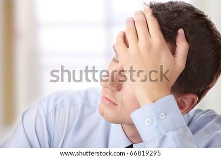 Businessman in depression with hand on forehead
