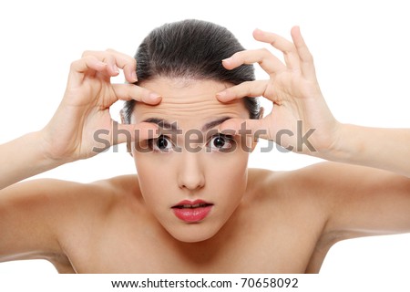 Woman checking her wrinkles on her forehead - isolated on white