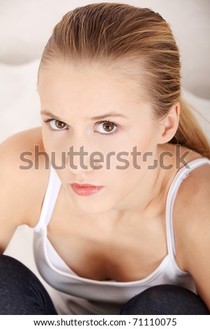 Young sad woman sitting on bed