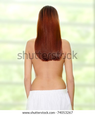 Rear view of beautiful young woman with healthy long hairs