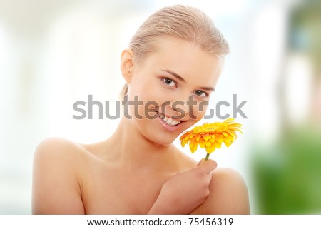Portrait of the attractive girl without a make-up, with flower in hand, isolated on white background