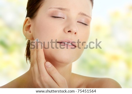 Woman applying moisturizer cream on face. Close-up fresh woman face.
