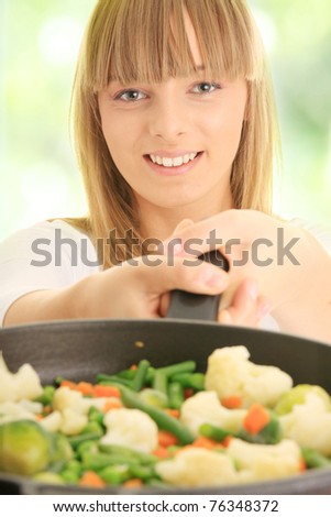 Image of a young woman cooking healthy food,against abstract green background