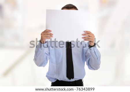 A businessman with a blank paper in his face