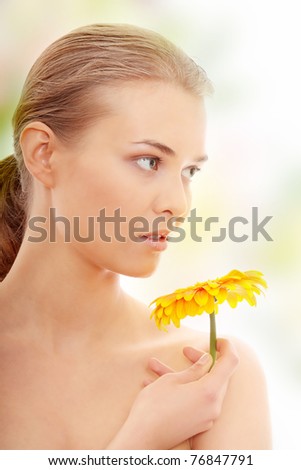 Portrait of the attractive girl without a make-up, with flower in hand