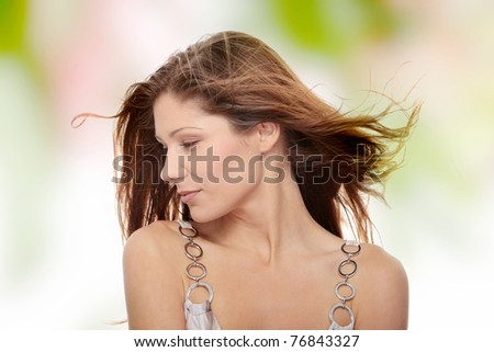 Young beautiful woman in elegant, evening, white dress dancing with wind (hair blowing).
