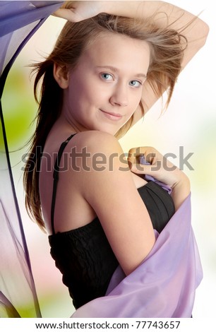 Young beautiful blond teen woman in elegant, evening, black dress dancing with wind (hair blowing)