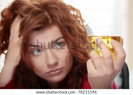 Alone young woman in depression, drinking alcohol (bourbon)