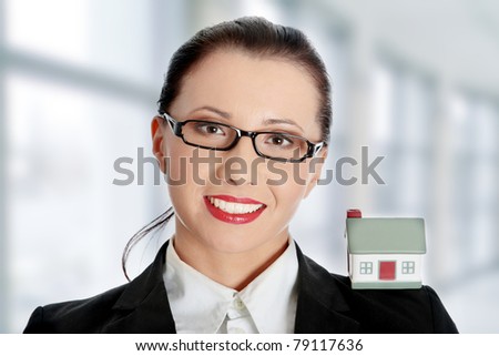 Young beautiful business woman with house model - real estate concept.