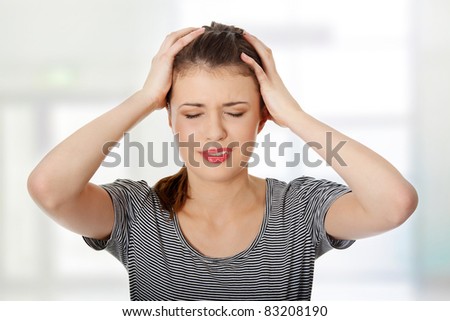 Teen woman with headache holding her hand to the head, isolated on white
