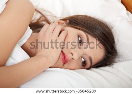 Young pretty girl lying in bed. Sad thinking