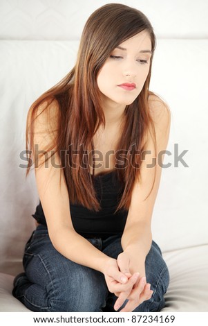 Sad young woman\'s sitting on couch. In home.