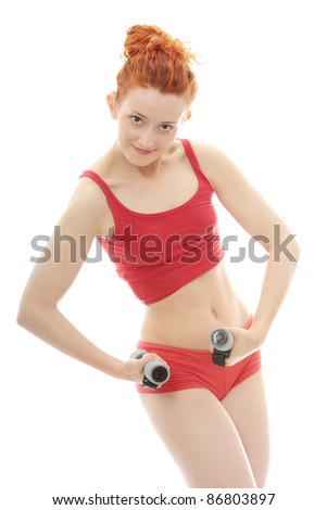 Beautiful, young, deaf (with hearing aid in ears) redhead exercising with dumb bells