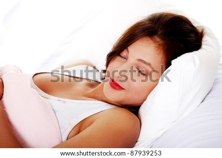 Pretty caucasian teen girl sleeping in bed over white.