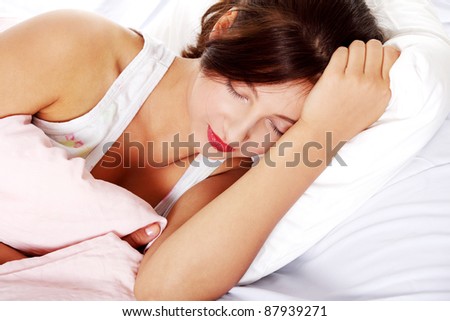 Pretty caucasian teen sleeping girl in bed over white.