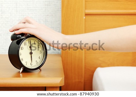 Female hand turning off alarm clock.