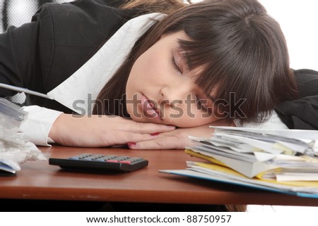 Sleeping female filling out tax forms while sitting at her desk. Isolated