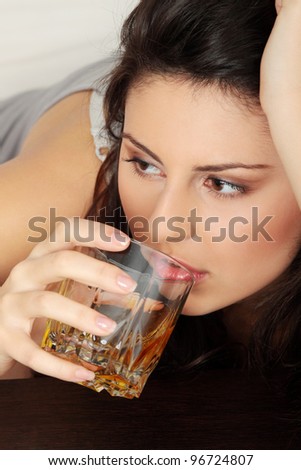 Young beautiful woman in depression, drinking alcohol
