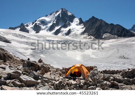 A tent is set up in a high mountain environment