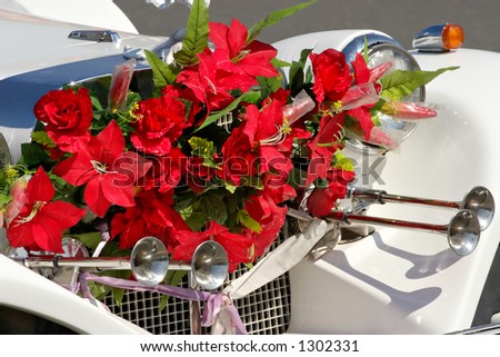 Wedding attribute-limousine with a bouquet of flowers on a cowl
