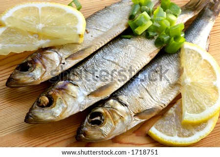 Smoked sprat-appetizing snack with a lemon and a green onions