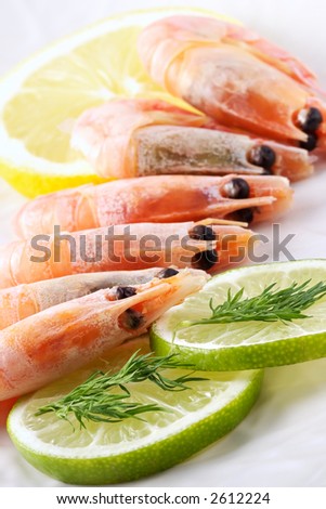 Shrimps laid out on a dish and seasoned by a lemon and spicy grasses-refined low-calorie snack