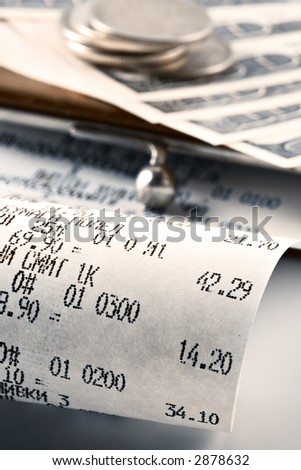 Cash receipt illustrating the spent money on background of a purse