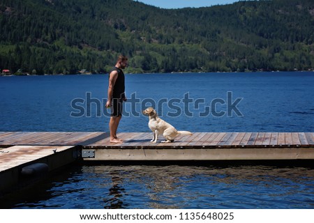 Active Mature Man and Yellow Lab Dog at the Lake