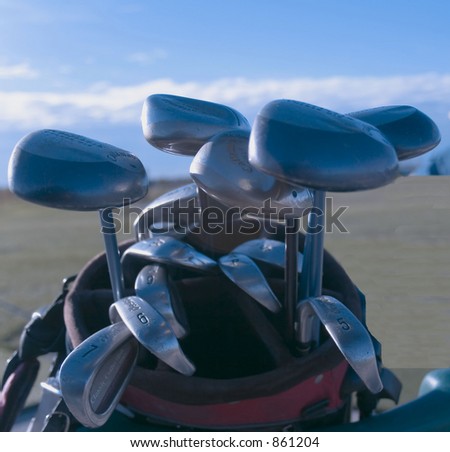 close up golf clubs against an azure blue sky