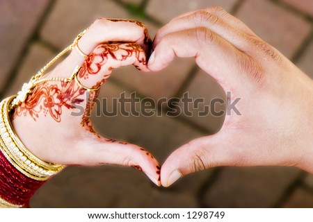 ceremonial wedding hands in shape of heart one male one female coming together to form heart