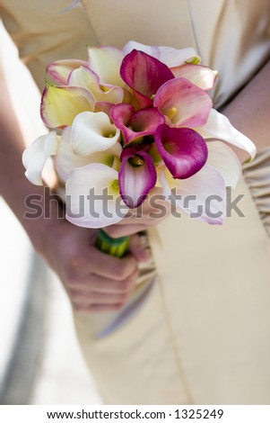 beautiful calla lillies on silk dress with hands wedding bouquet detail