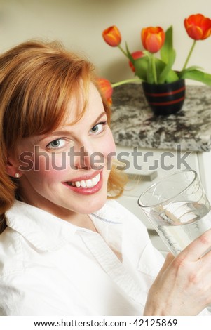 a pretty redhead takes a drink of cool clean water