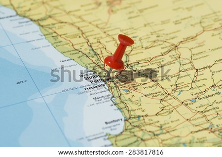 Perth marked on map with red pushpin. Selective focus on the word Perth and the pushpin. Pin is in an angle and casts some shadow to the right.