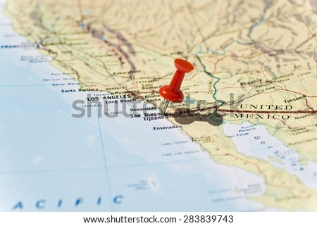 San Diego marked on map with red pushpin. Selective focus on the word San Diego and the bottom of pushpin. Pin is in an angle and casts shadow to the right.