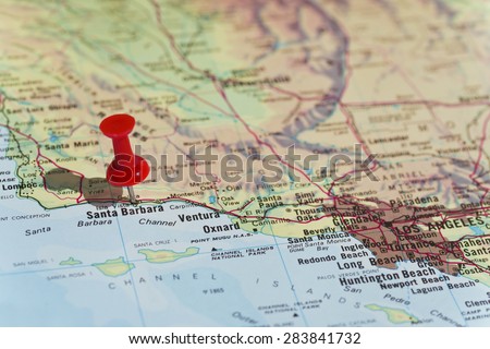 Santa Barbara marked on map with red pushpin. Selective focus on the word Santa Barbara and the pushpin. Pin is in an angle and casts some shadow to the left. Los Angeles can be seen on map.