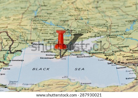 Jalta (Yalta) in Crimea Ukraine marked with red pushpin on map. Selected focus on Jalta and pushpin. Pushpin is in an angle and casts shadow to the right.