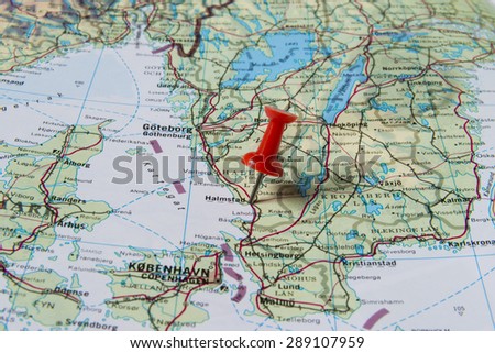 Halmstad marked with red pushpin on map. Selected focus on Halmstad and bright red puspin. Pushpin is in an angle. Southern parts of Sweden can be seen on map.