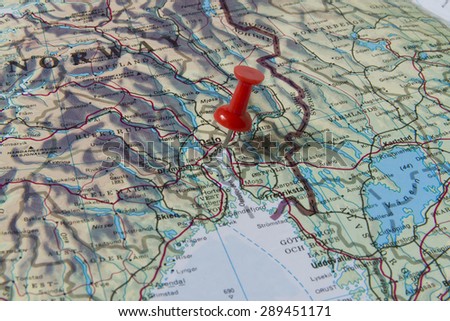 Oslo marked with red pushpin on map. Selected focus on Oslo and bright red pushpin. Pushpin is in an angle. Some parts of Norway and Sweden can be seen on map.