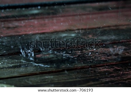 A highspeed photo of a rain drop hitting a wooden deck. Tri-toned for better contrast.