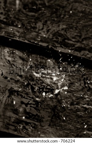 A highspeed photo of a rain drop hitting a wooden deck. Tri-toned for netter contrast.