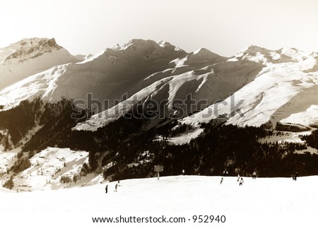 Skiers on a slope, mountains in the background. Taken in Davos, Switzerland. Image modified to resemble an old silver plate print.
