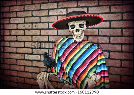 Latino skeleton sitting against a brick wall having a smoke with his trusty pet crow.